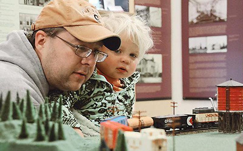 man and girl looking at toy train