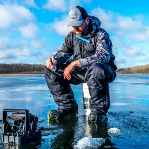 man ice fishing on a frozen lake in minnesota